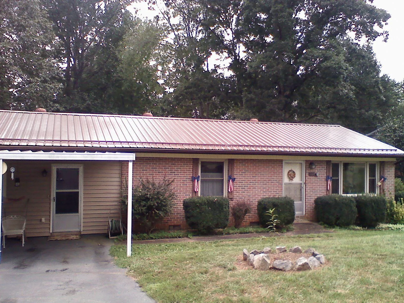 Bronze metal roof and carport on a brick ranch home — Roof Repair work by our crew in Pearl River