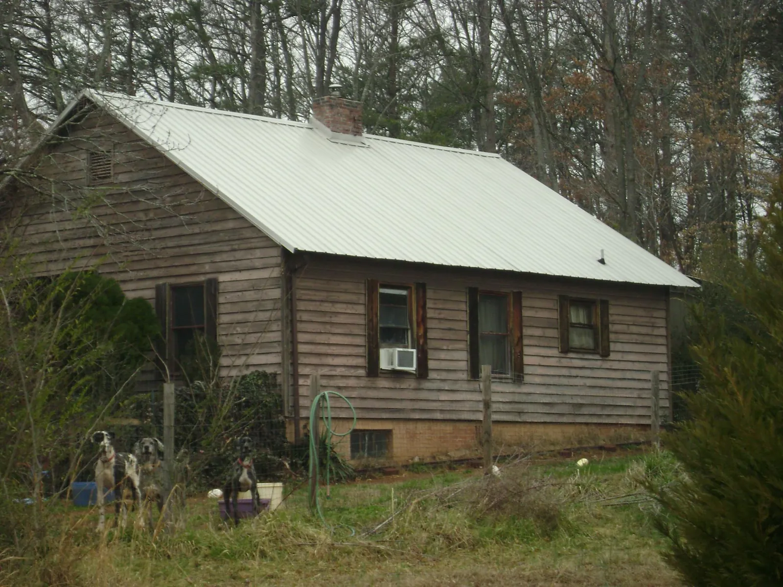 White metal roof on an old wood sided farmhouse, from a Metal Roof Installation job in Pearl River